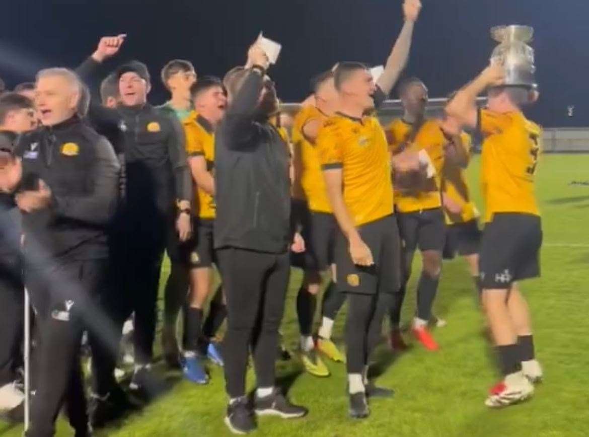 The players celebrate with the trophy