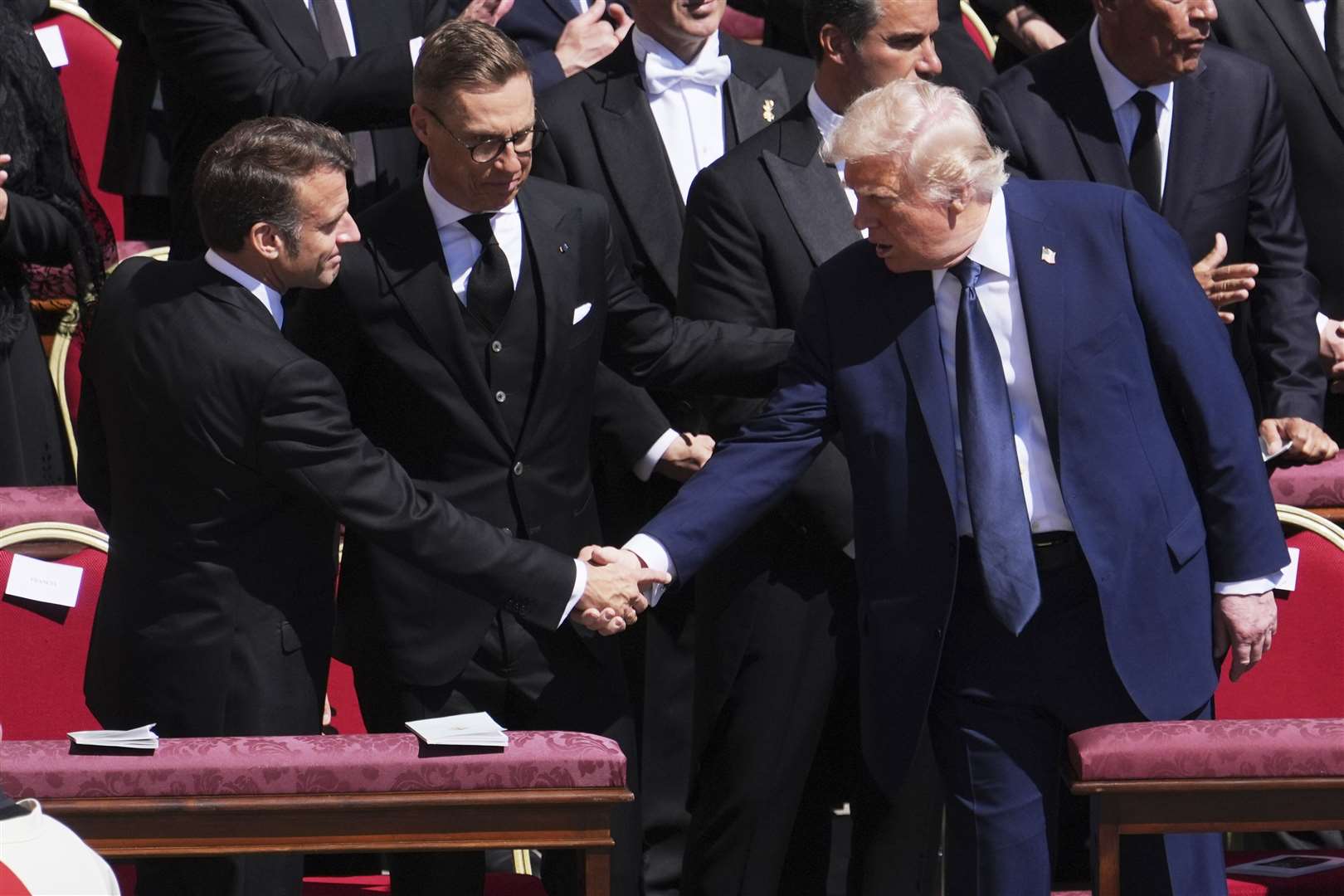 US President Donald Trump shakes hands with French President Emmanuel Macron during the service (Evan Vucci/AP)