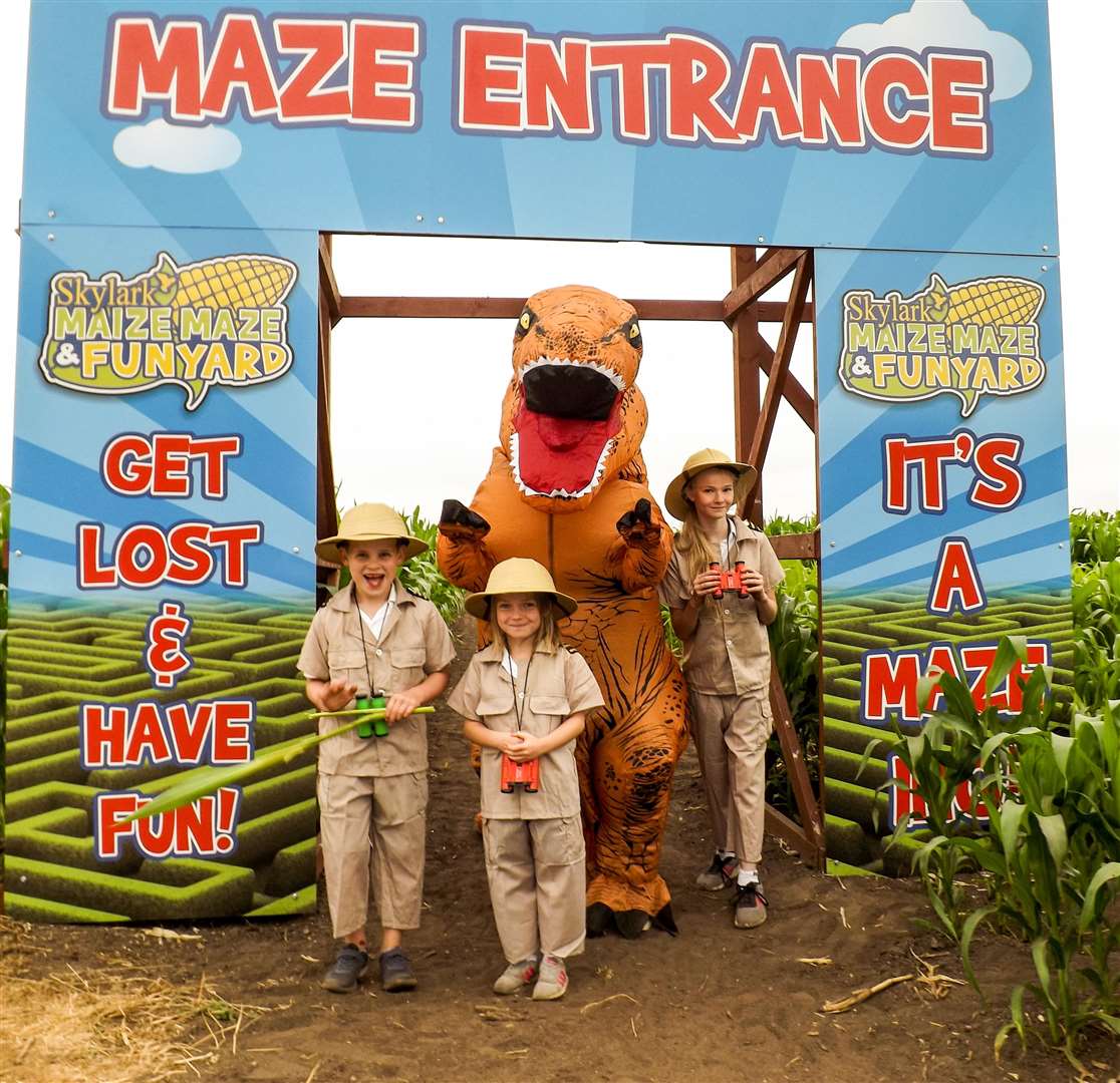Owen Askew, 7, Amelia Hathaway, 6, and Annabell Wesley, 11, with the dinosaur at the entrance to the maize maze. (3047051)