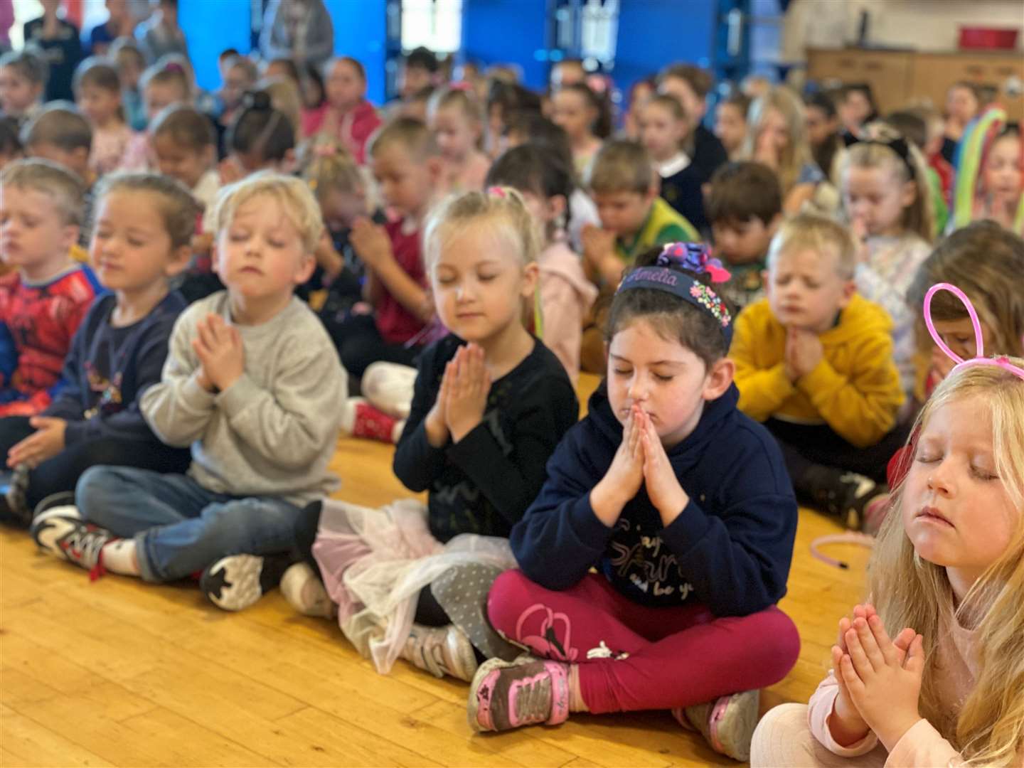 Pupils taking part in prayers during assembly