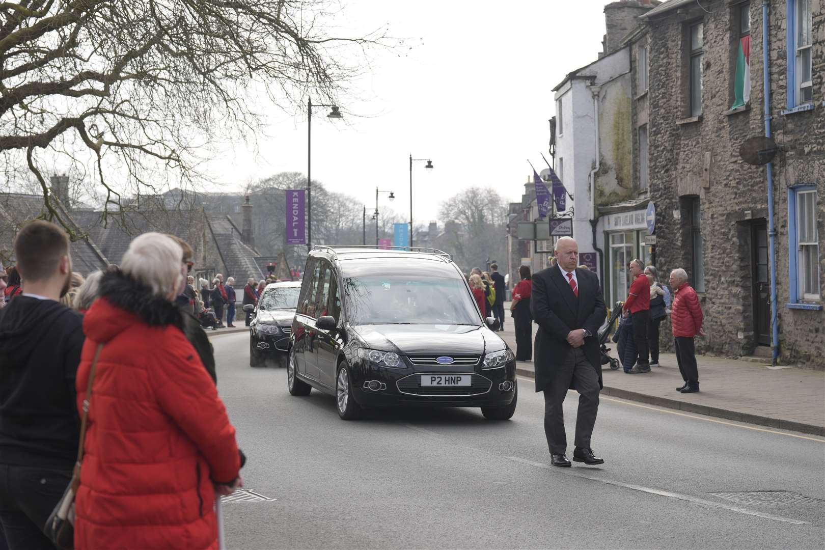 People wore red as they lined the streets ahead of Poppy Atkinson’s funeral (Danny Lawson/PA)
