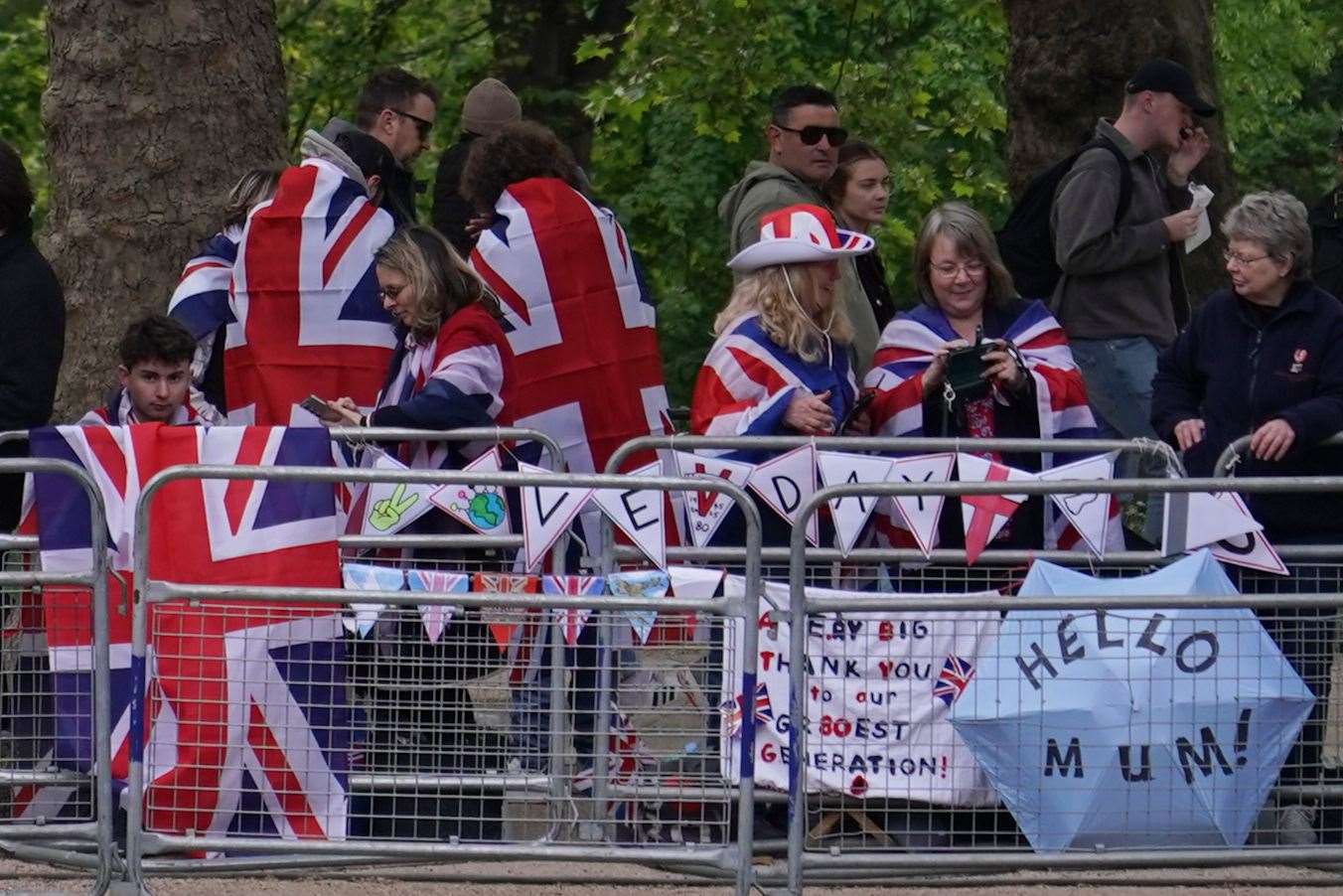 Members of the public draped in Union flags ahead of the military procession (Alberto Pezzali/PA)