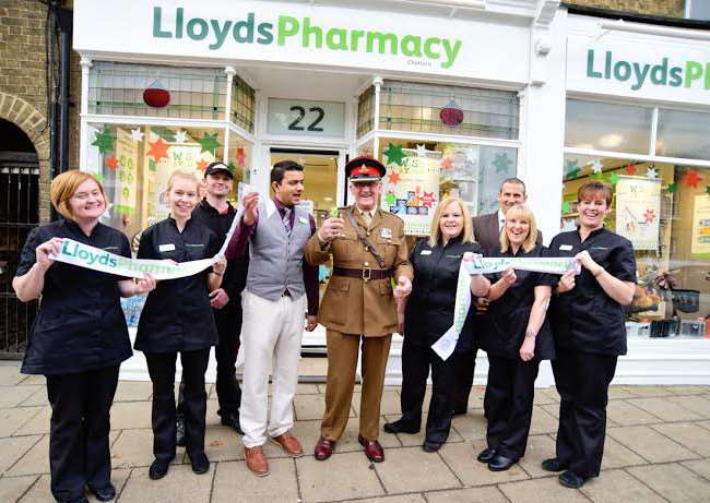 Malcolm Punter cuts the ribbon, watched by pharmacy manager Jigar Raval and his team at the newlook pharmacy in Chatteris High Street.