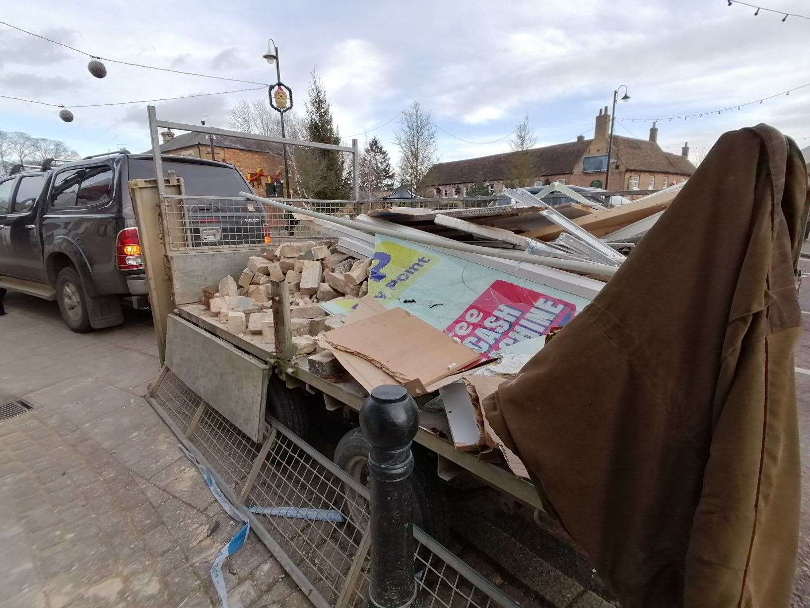 A trailer load of debris is all that remains of the nIsa store shop front. (54143548)
