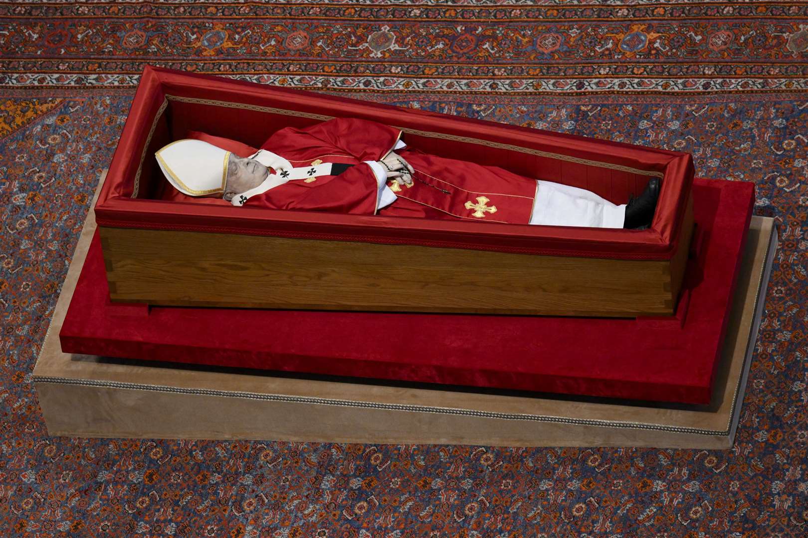 The Pope’s simple wooden coffin has been positioned low to the ground at his request (Vatican Media via AP)