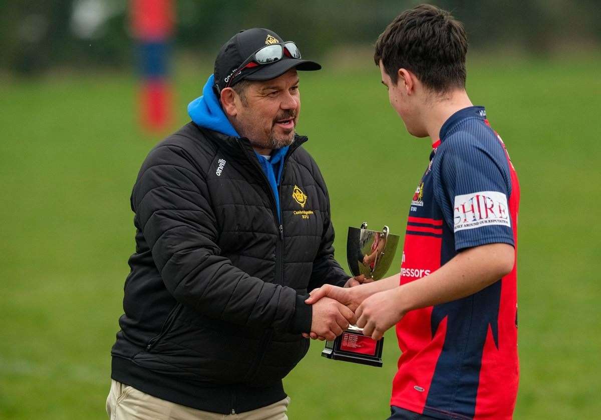 Cambridgeshire County RFU Chairman John Evans awards the champions trophy to Wisbech U16 captain Tom Ryan. pICTURE: aNDY tITMUSS