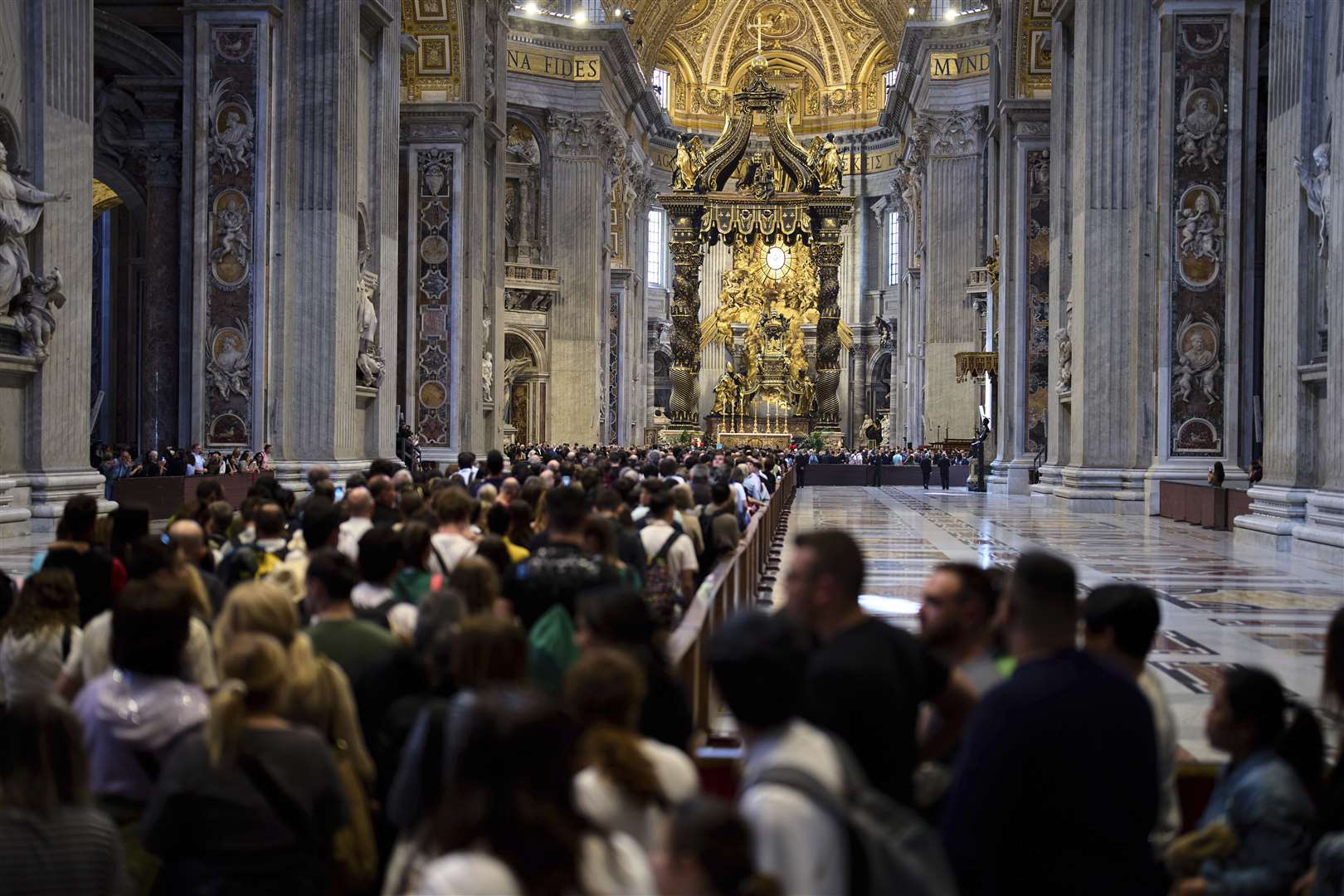 People wait in a line to pay their respects inside St Peter’s Basilica at the Vatican (Domenico Stinellis/AP)