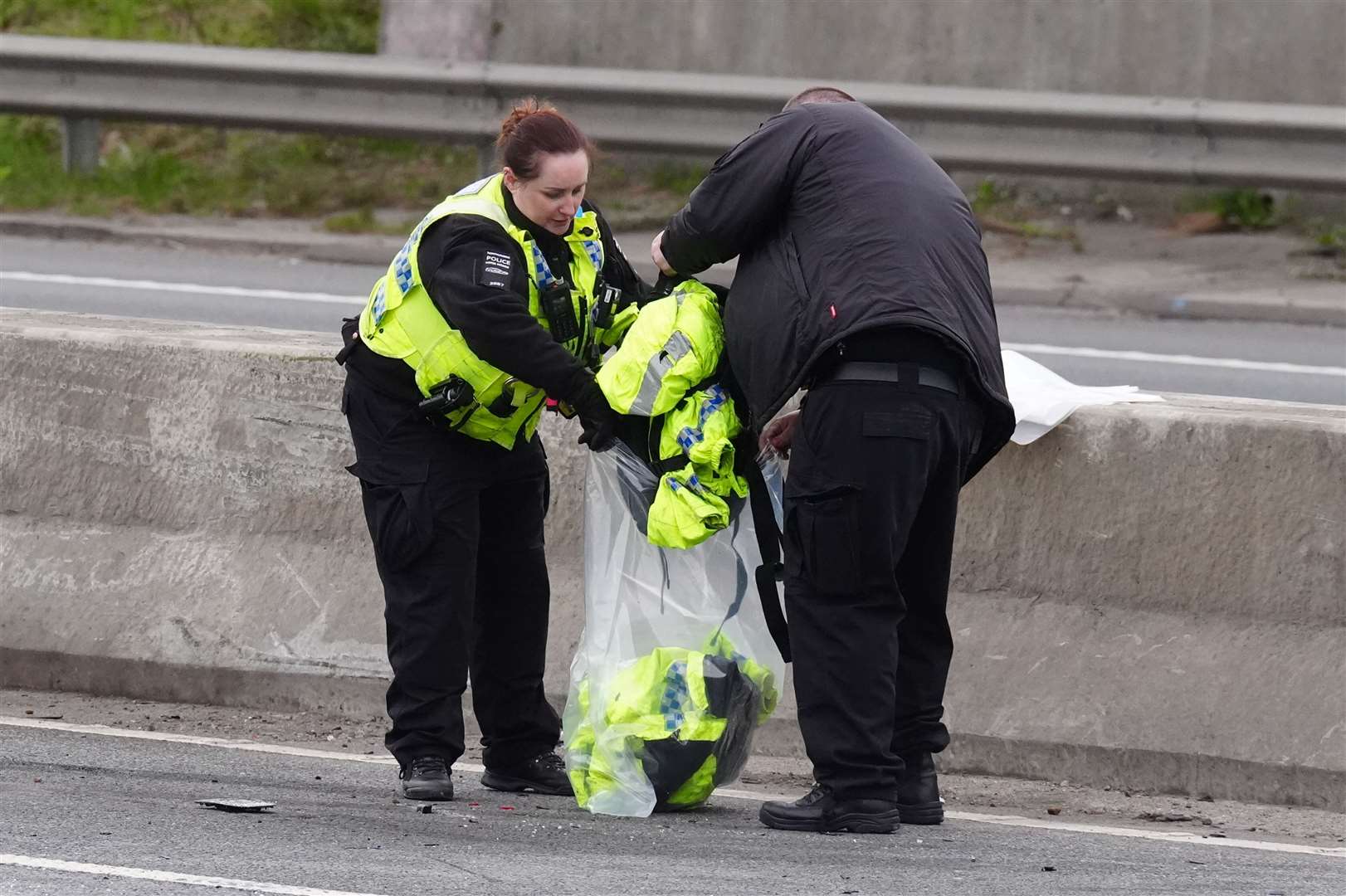 Emergency services personnel retrieve police clothing from the scene (Owen Humphreys/PA)
