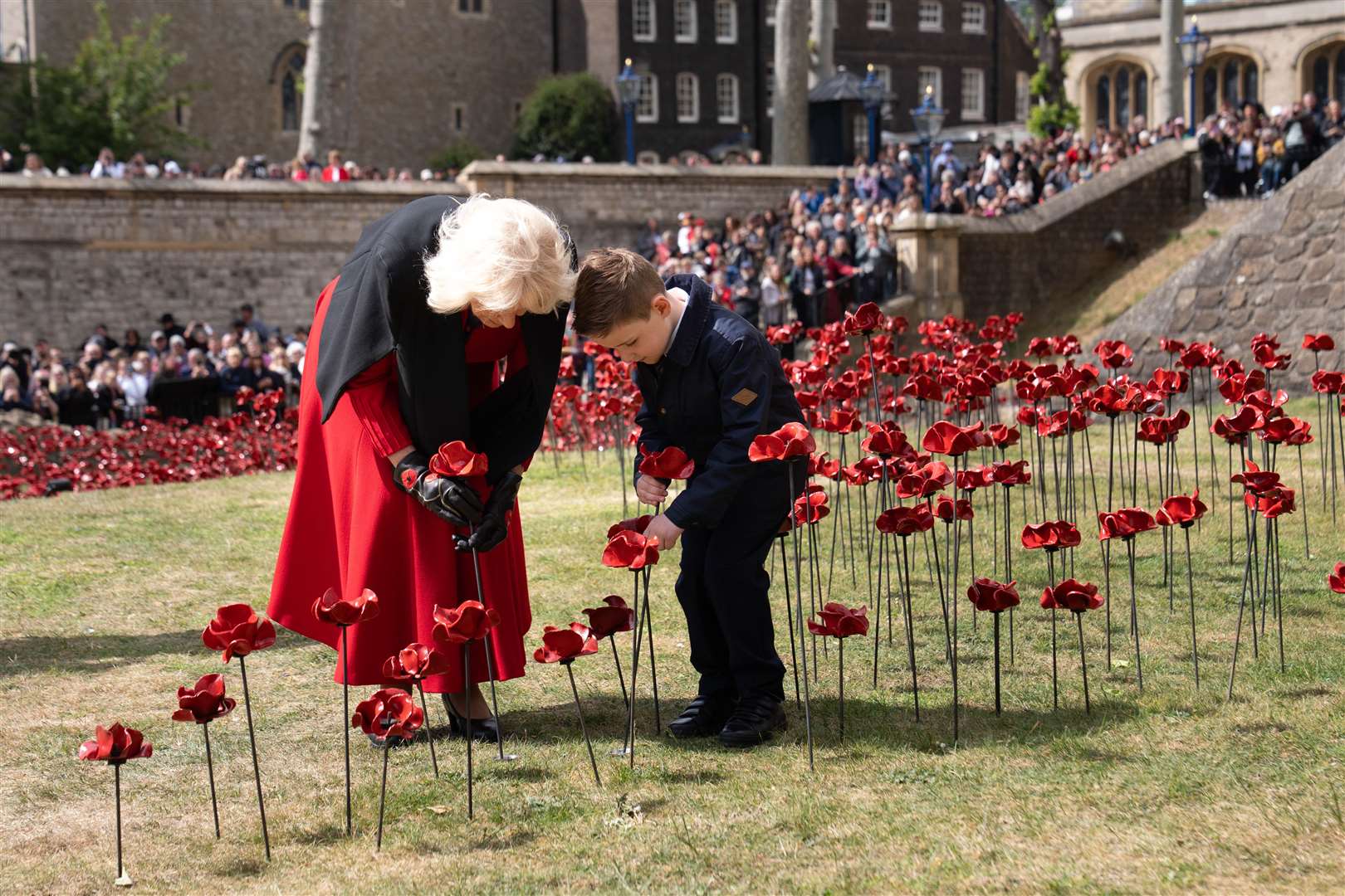 The Queen gets help with planting a poppy (Stefan Rousseau/PA)
