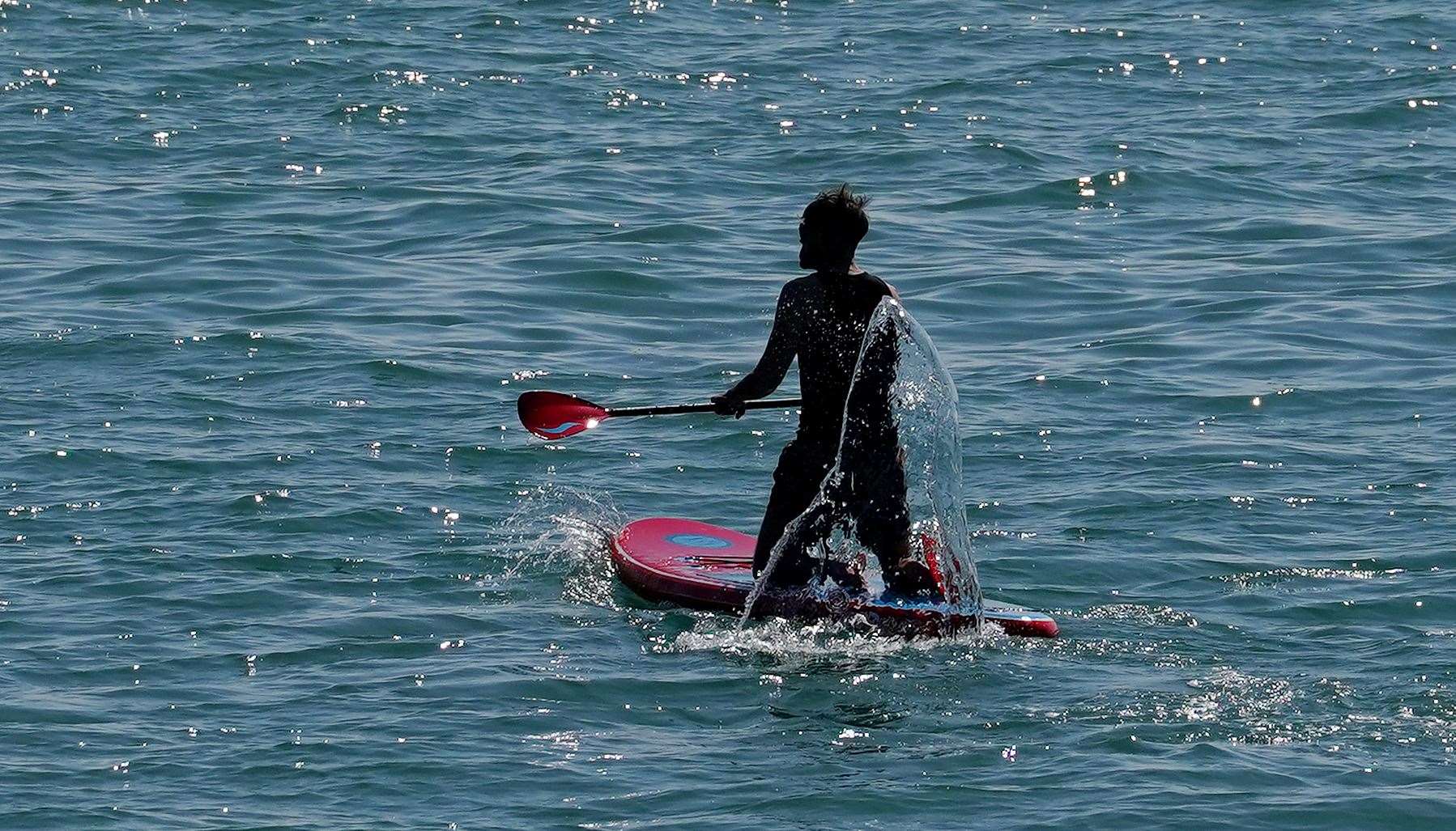 A paddleboarder enjoys the morning sunshine in Dover (Gareth Fuller/PA)