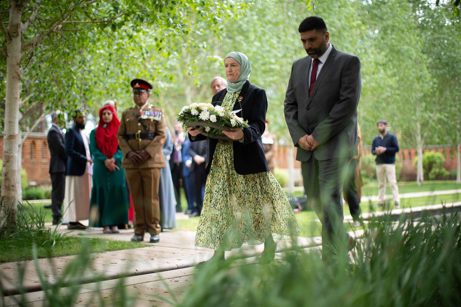 A person holding a wreath in the Peace Garden in Woking, ahead of a VE Day 80th anniversary interfaith afternoon tea party, at the Shah Jahan Mosque in Woking (James Manning/PA