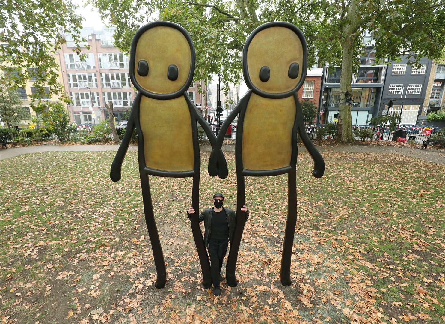 The artist poses with the original Holding Hands artwork in Hoxton Square in east London (Yui Mok/PA)