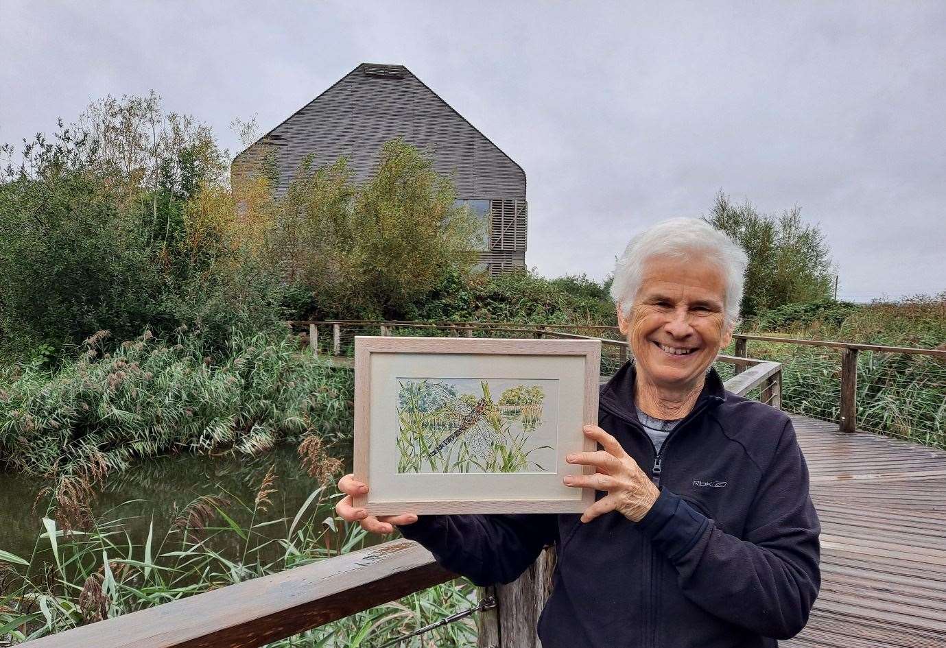 Ann Biggs at WWT Welney with her original hand-painted dragonfly. Picture: WWT Welney