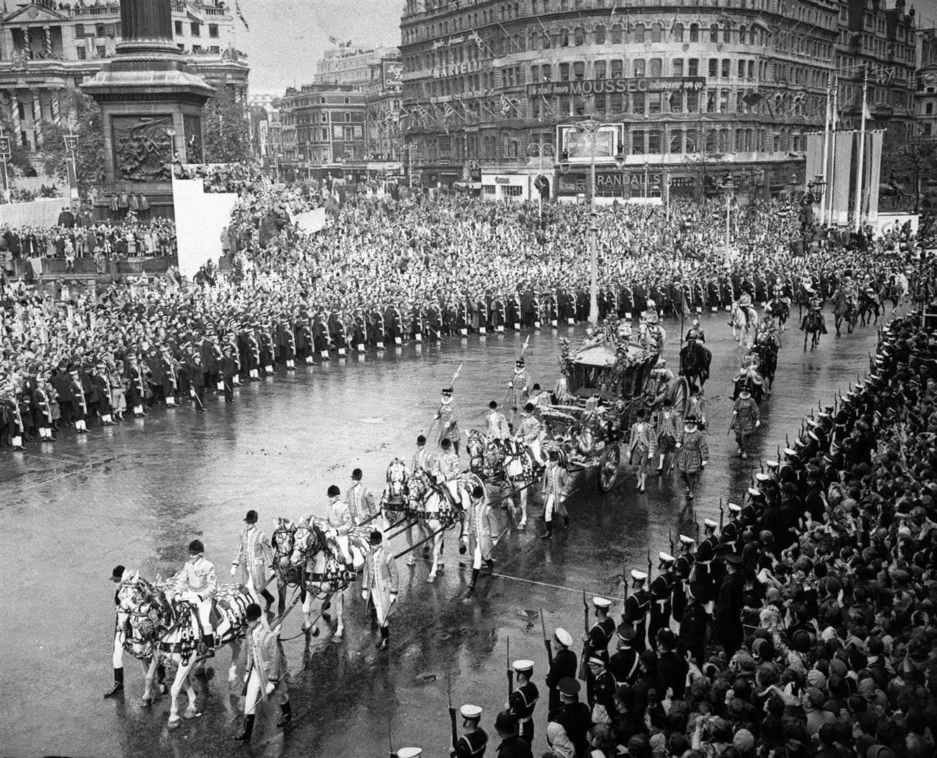 Queen Elizabeth II rides in the Gold State Coach past cheering crowds. PA Photo.