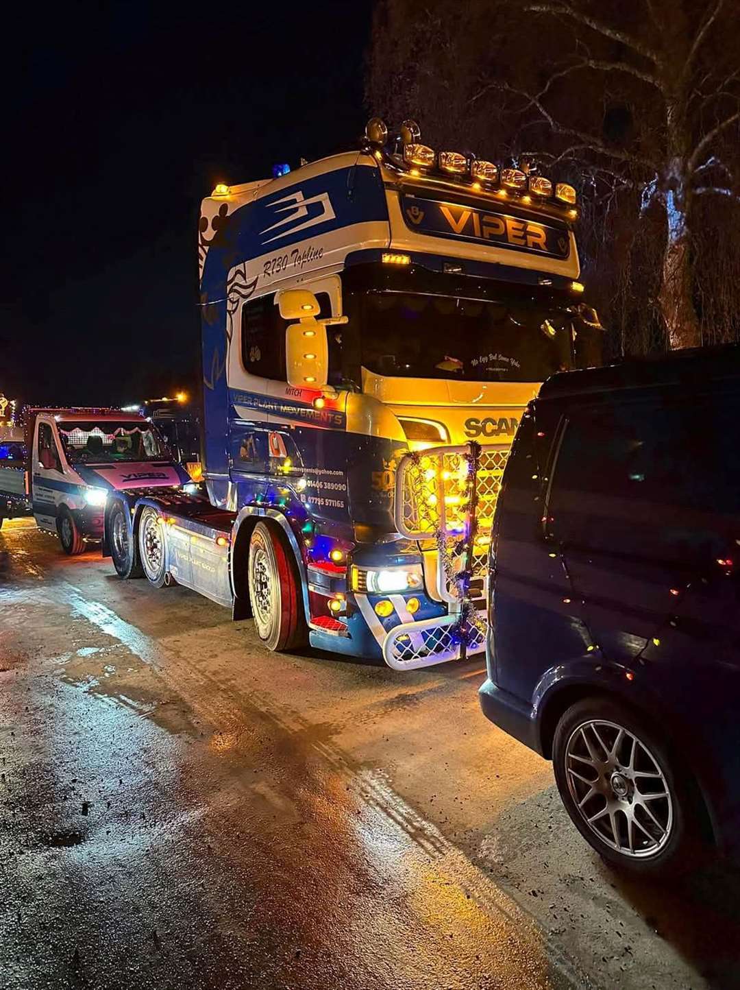 Brightly lit lorry makes its way with hundreds of vehicles
