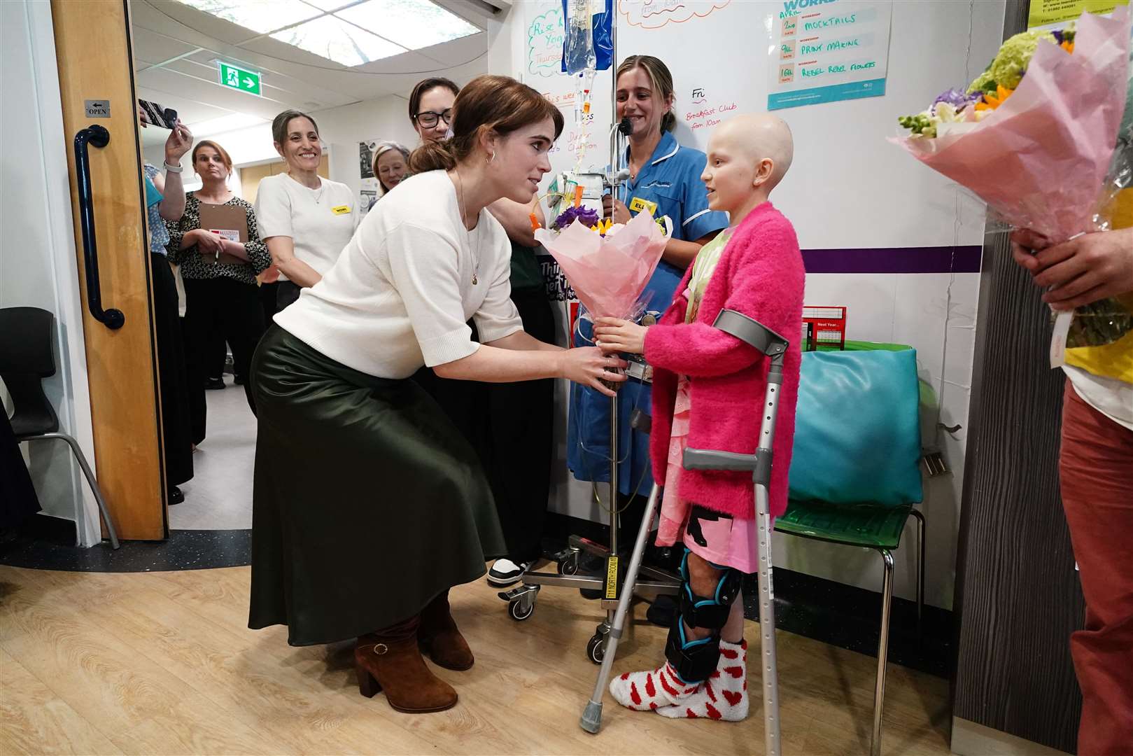 Cancer patient Lola Belle Tucker presents Eugenie with flowers (Aaron Chown/PA)