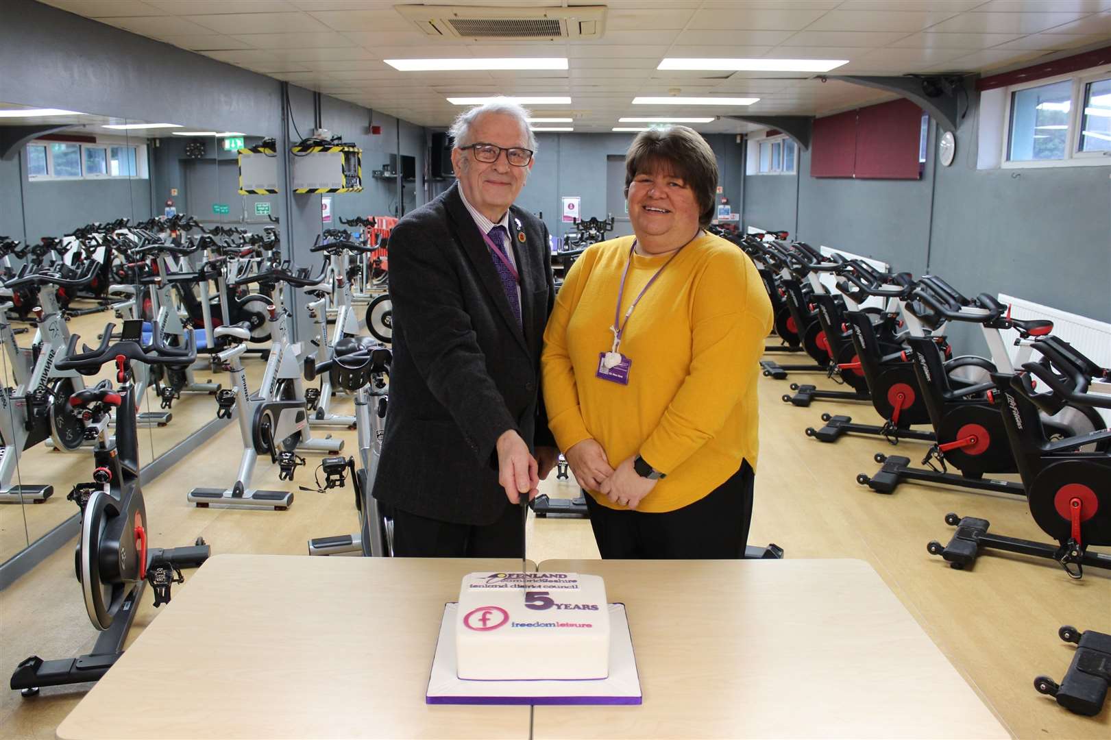 Cutting a celebratory cake to mark five years of partnership between Fenland District Council and Freedom Leisure are Cllr Alex Miscandlon, Fenland District Council’s portfolio holder for leisure and Cllr Sam Clark, who was the Council’s portfolio for leisure when the partnership began.