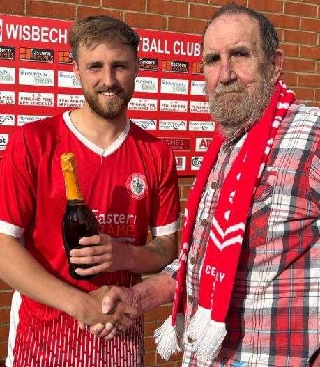 Sam Bennett receives his Wisbech Town Supporters' Club man of the match award from member John Rowland