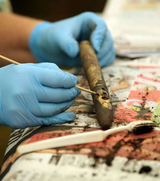 Volunteer Alexandra Edwards works on a recovered Pitot Tube as archaeologists excavate a site near Holme Lode Farm. Photo credit: Chris Radburn/PA Wire