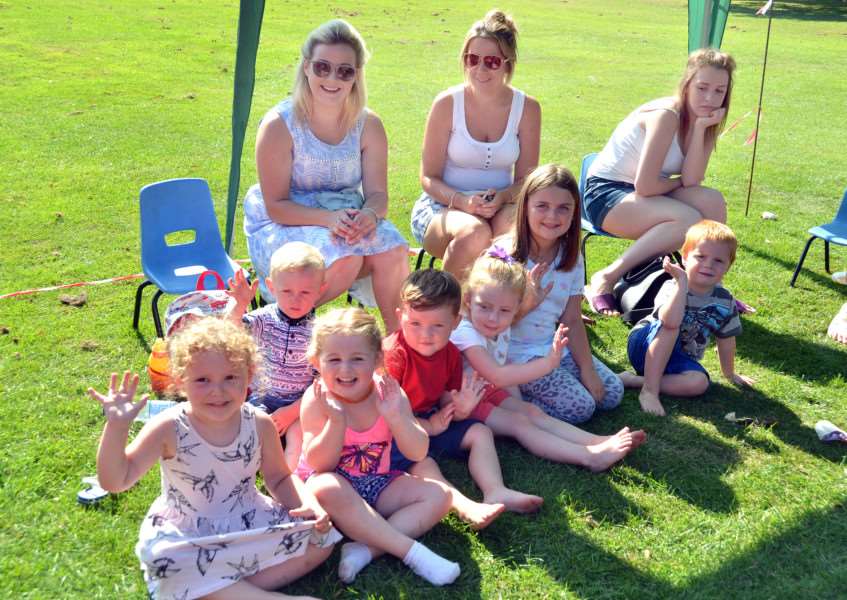 Youngsters and mums sit in the shade under a gazebo outside The Pavilion. Photo by Tim Wilson.