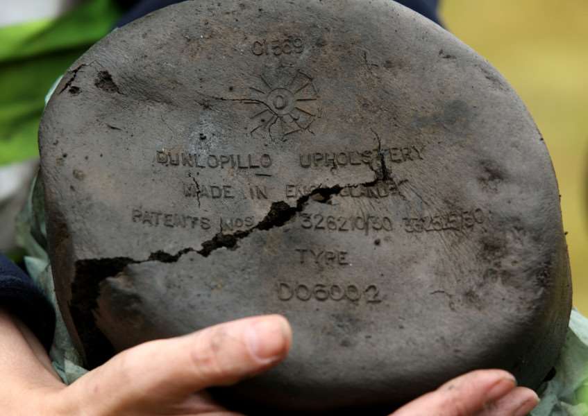 A Volunteer holds the the remains of a pillow as archaeologists excavate a site near Holme Lode Farm in Cambridgeshire. Photo credit: Chris Radburn/PA Wire