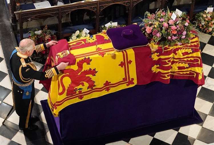 The King places the the Queen’s Company Camp Colour of the Grenadier Guards on the coffin at the Committal Service for Queen Elizabeth II, held at St George’s Chapel in Windsor Castle (Jonathan Brady/PA) (61597415)