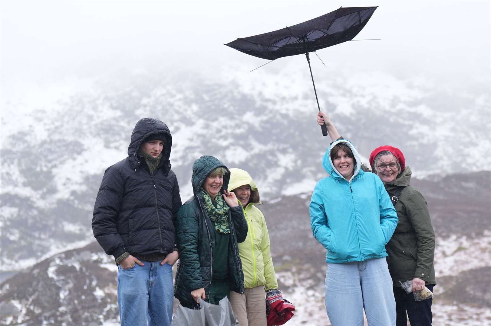 People in the windy and snowy conditions at Lough Bray Upper (Niall Carson/PA)