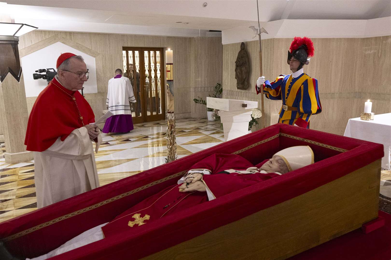 Vatican secretary of state Cardinal Pietro Parolin prays in front of the body of Pope Francis laid out in state inside his private chapel at the Vatican (Vatican Media via AP, HO)