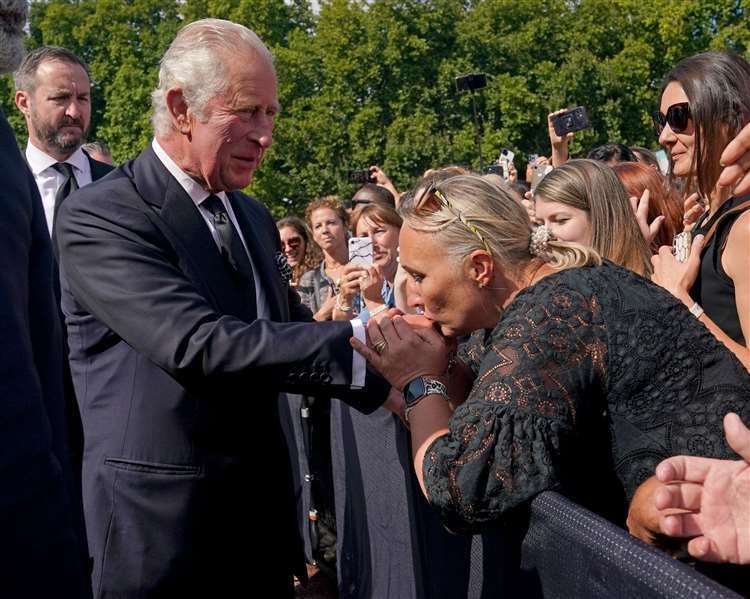 A well-wisher kisses the hand of the King during a walkabout outside Buckingham Palace, London, to view messages and tributes following the death of the Queen (Yui Mok/PA) (61597421)