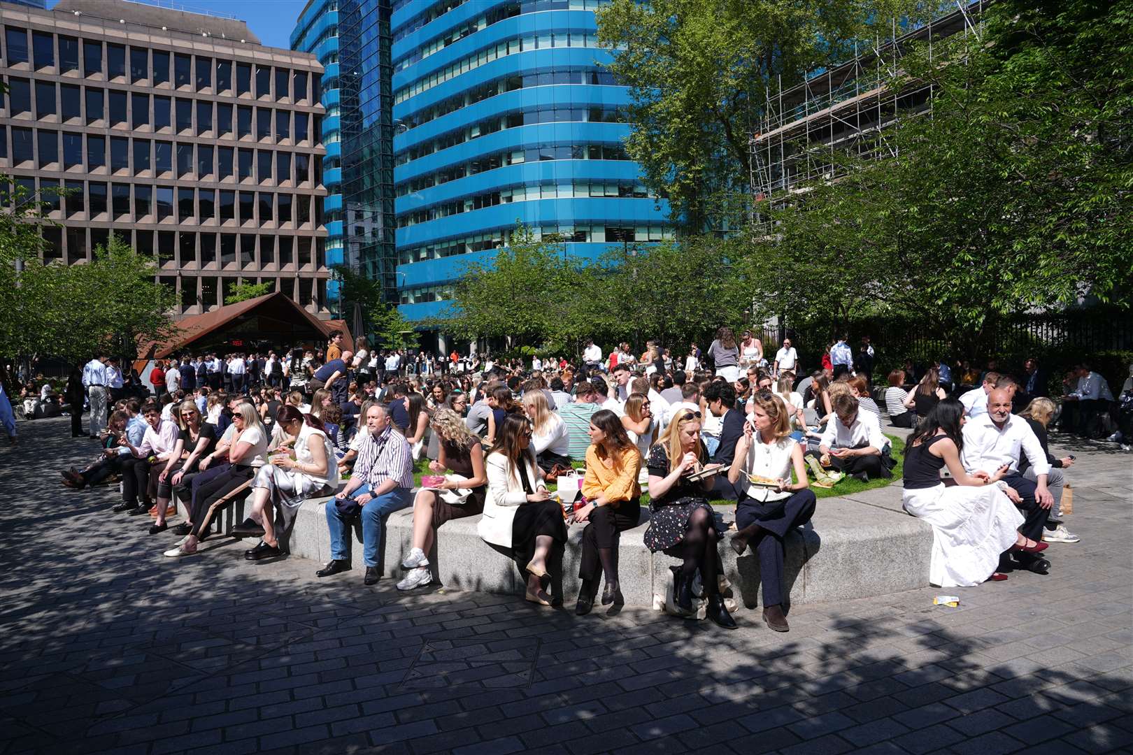 People enjoying the sunshine in Aldgate Square, London (Lucy North/PA)