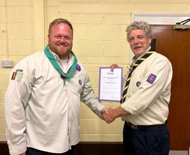 Ian Bullard, Fenland District Commissioner, presents Paul Dunham (left) with his 15 years' service award.