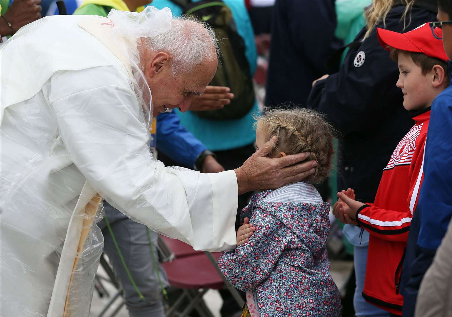Francis blesses a young girl queuing for communion during the closing mass of his visit to Ireland at Dublin’s Phoenix park in August 2014 (PA)