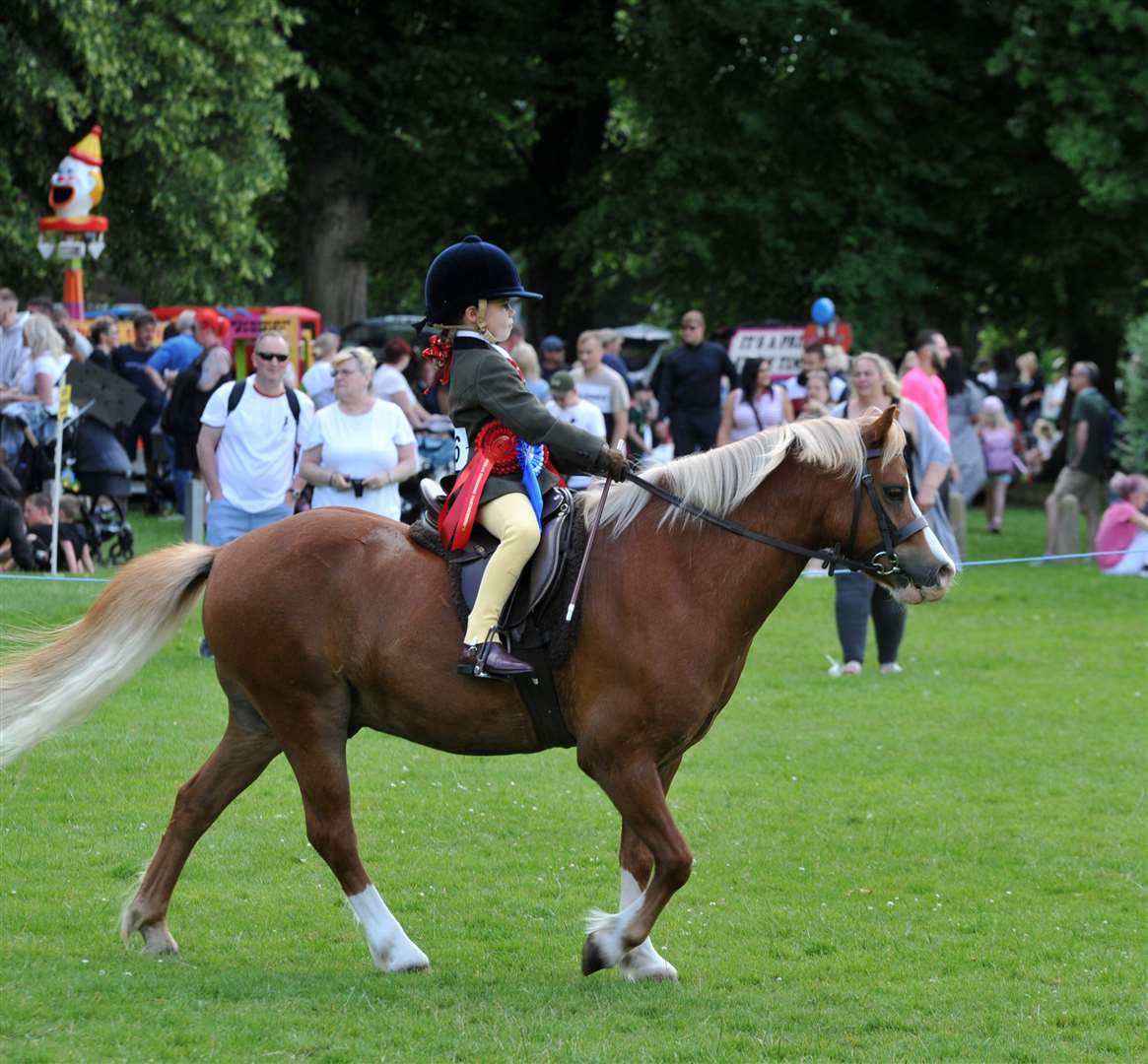A young rider proudly shows off her horse