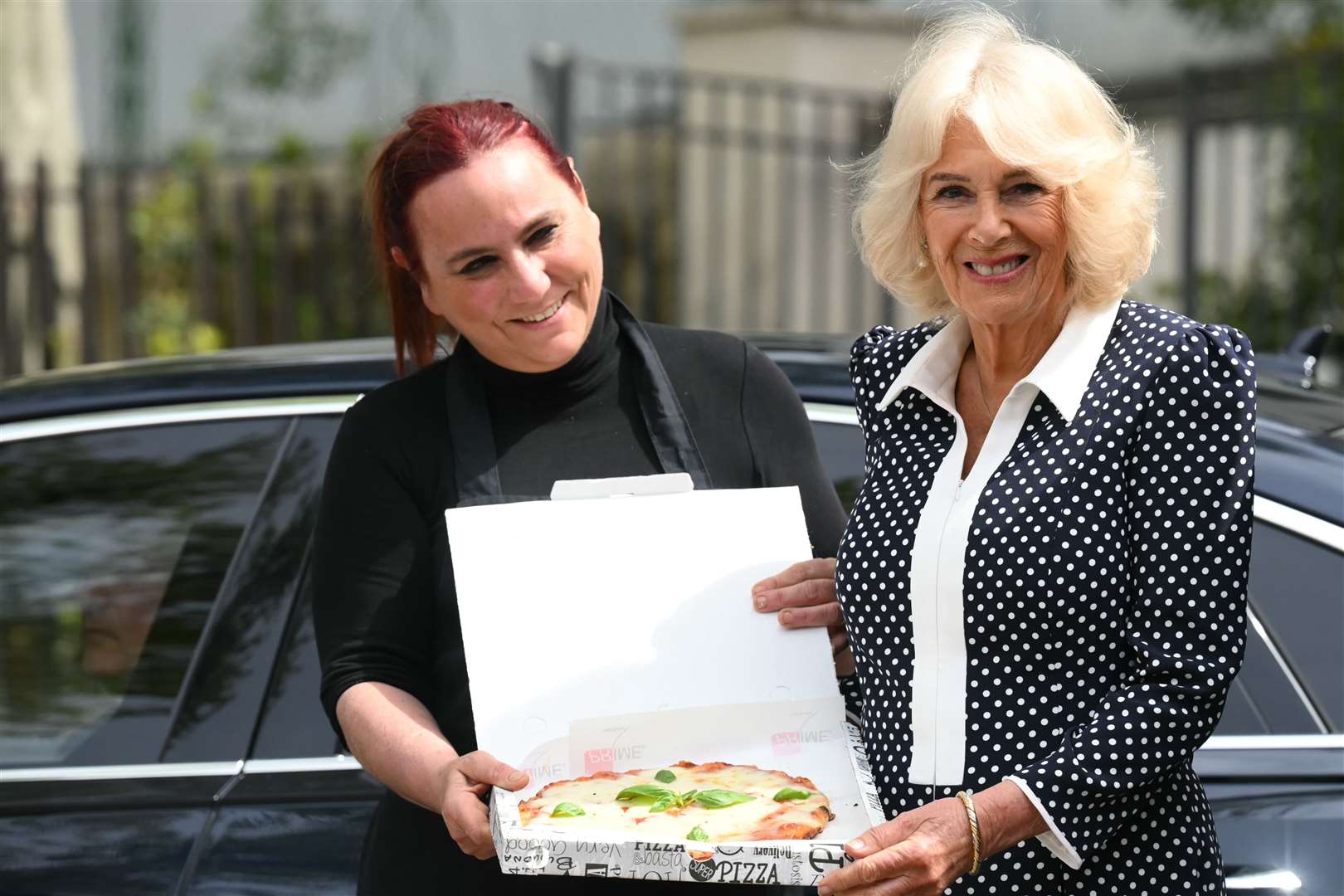 Queen Camilla is presented with a pizza during a visit to the Istituto Comprensivo Alessandro Manzoni, a local state school in Rome (Paul Ellis/PA)