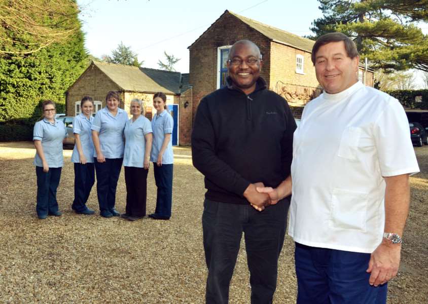 CHANGING HANDS: Dr Garwyn Elias (right) hands over The Lawns Dental Practice in Long Sutton to Dr Petros Mapanda as staff members look on. Photo by Tim Wilson. SG140217-102TW.