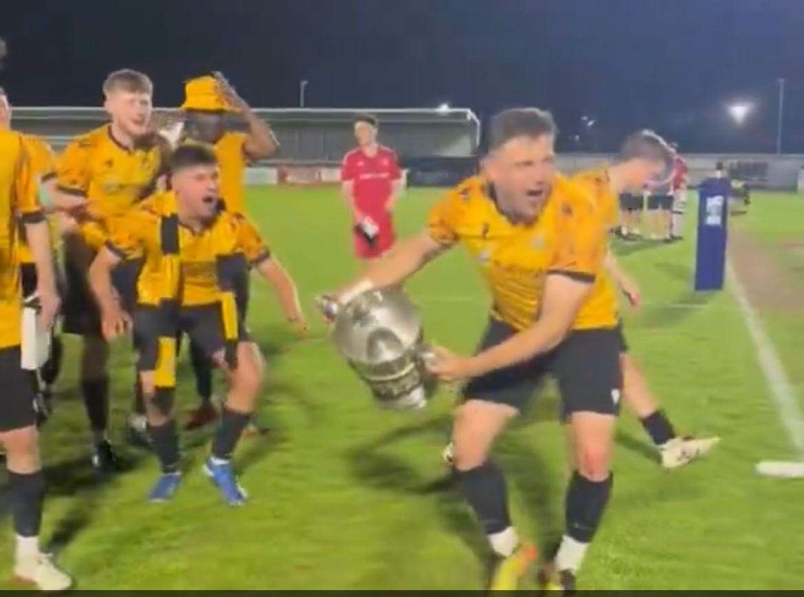The players celebrate with the trophy