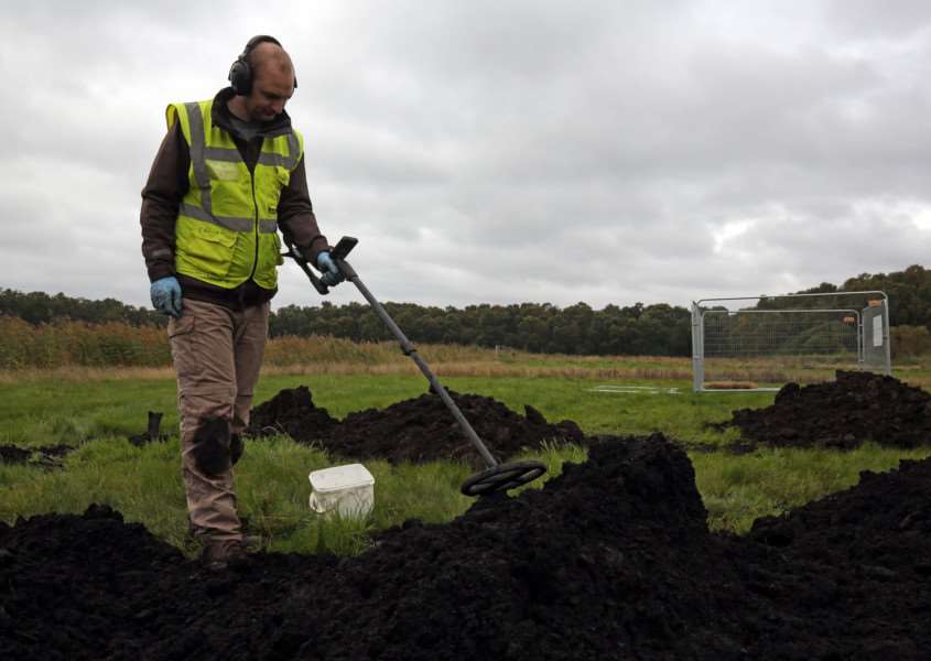 Volunteer Thomas Sigsworth from Leeds uses a metal detector to scan through top soil as archaeologists excavate a site near Holme Lode Farm in Cambridgeshire. Photo credit: Chris Radburn/PA Wire