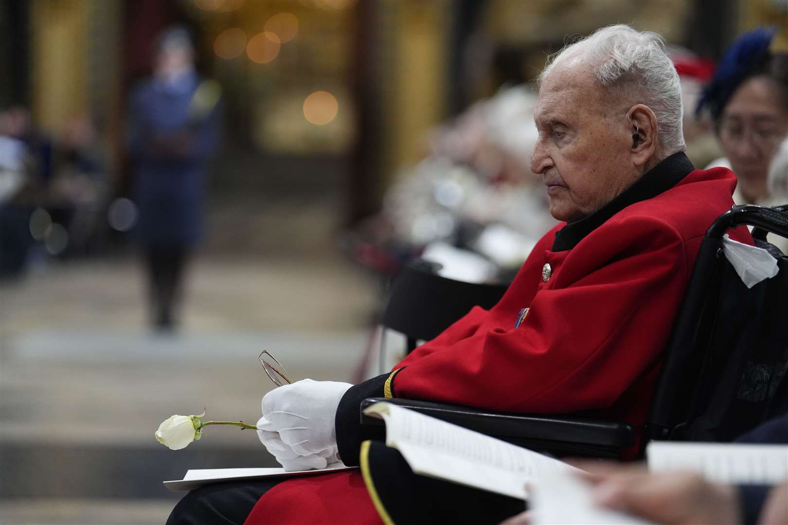 A veteran holds a white rose during a Service of Thanksgiving at Westminster Abbey (Jordan Pettitt/PA)