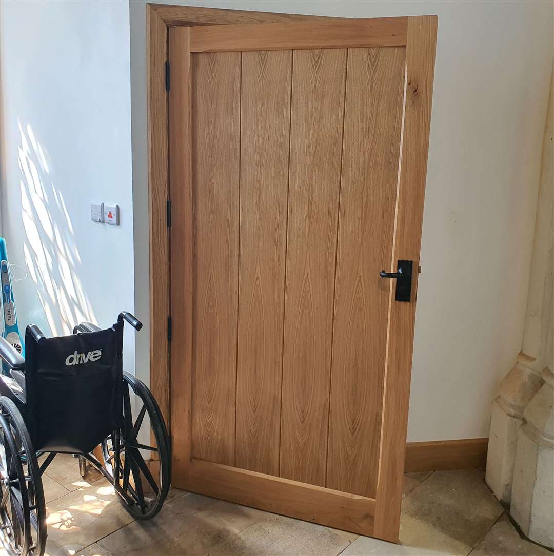Bespoke wooden door leads into the accessible toilet handmade by Steve Strickland & Co
