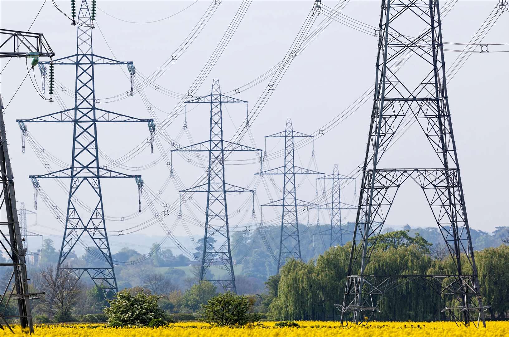 Multiple electricity pylons in an English landscape..