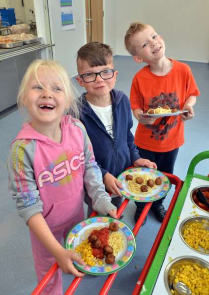 Long Sutton Primary School pupils Jade Sheldon-Morris, Laker Spelman and Nikoden Brodea collect their dinners from the school's new kitchen. Photo by Tim Wilson.