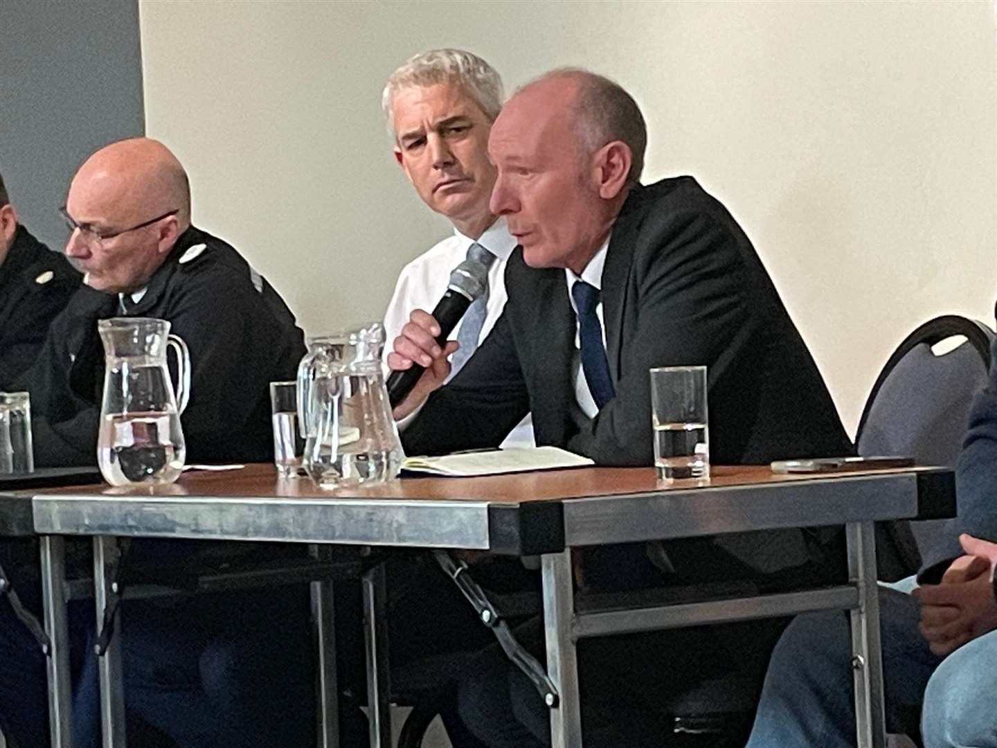 Cambridgeshire's Police and Crime Commissioner tells the packed hall he will hold the police to account as MP Steve Barclay watches on with Chief Constable Nick Dean, pictured left