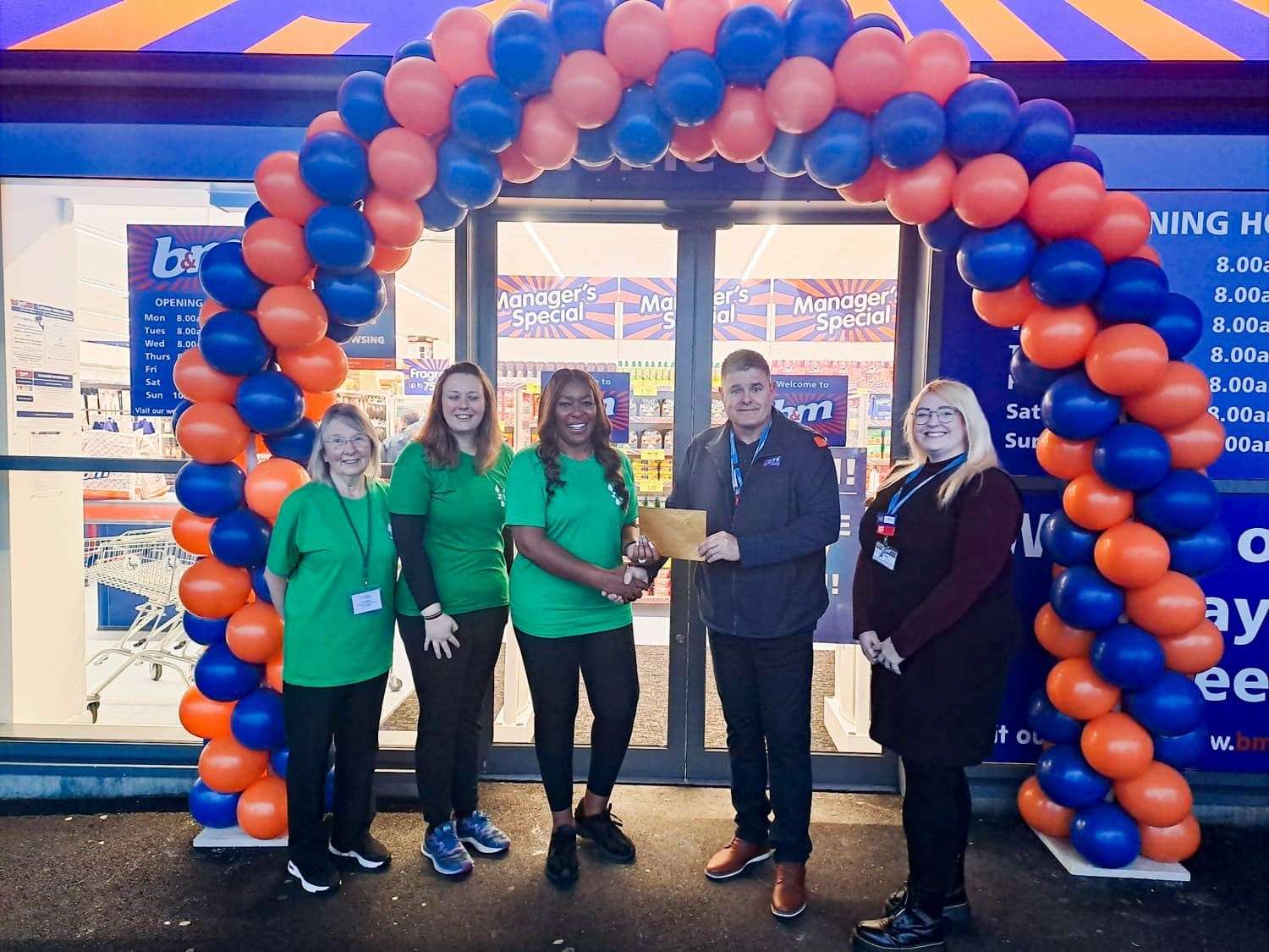 The store manager presents Chatteris Foodbank with a donation following its opening.