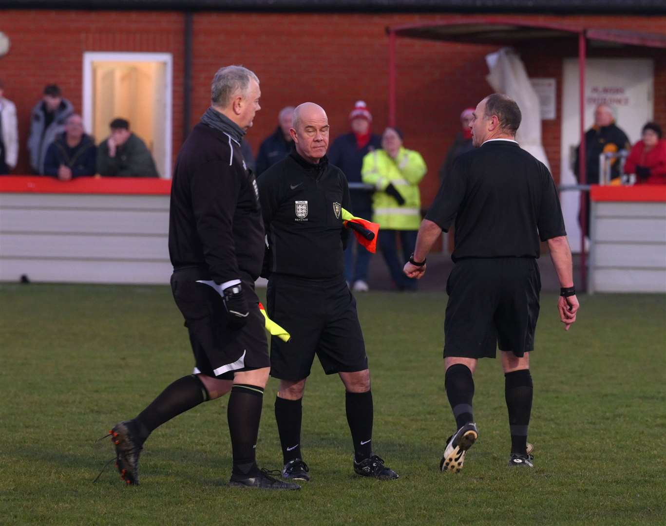 Referee Mark Simmons consults assistants Paul O'Shea and Phillip Hayes before the first dismissal