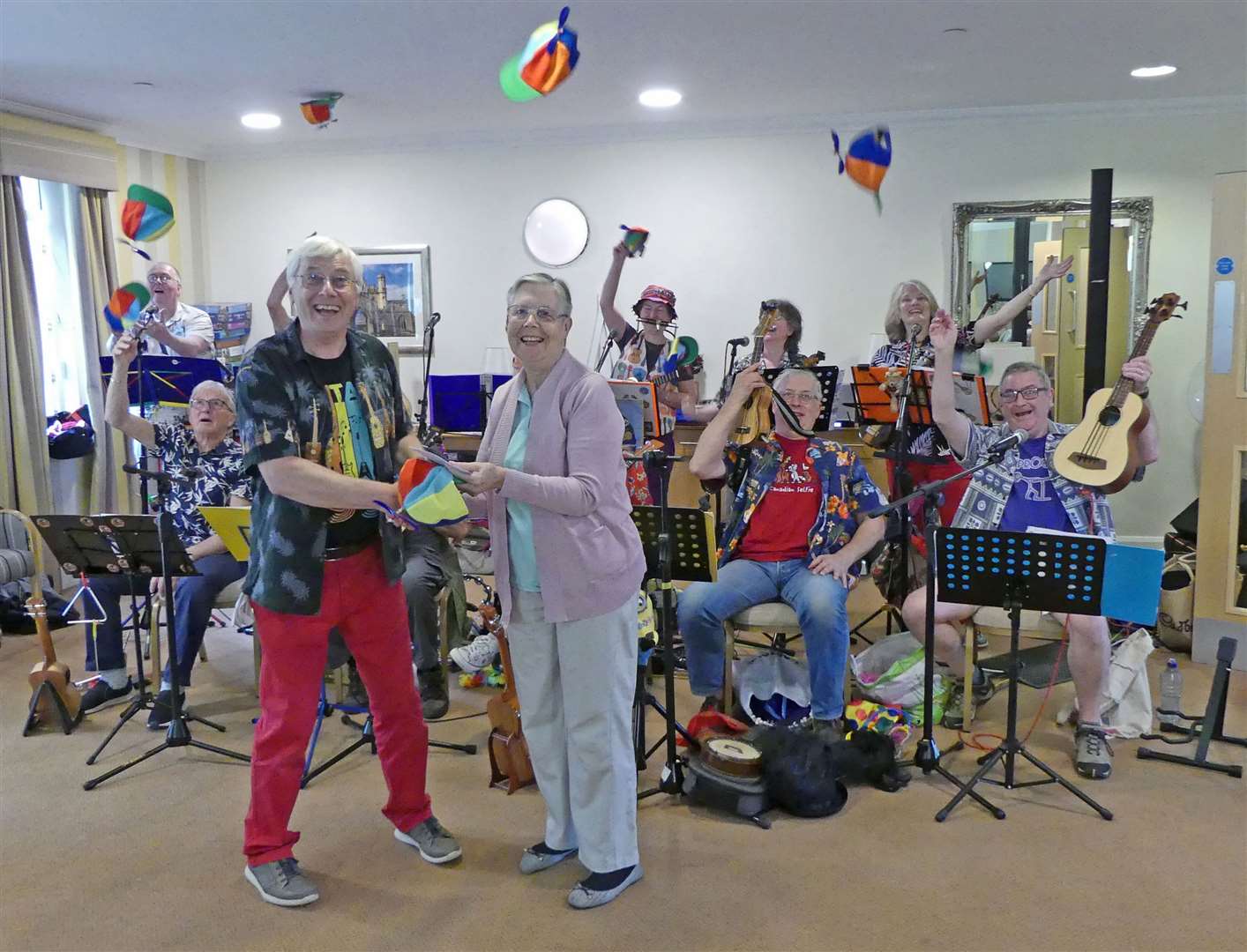 Pam Hawes presents a cheque to Doug McLeod at Doddington Court to help the Upwood Ukuleles smash their fundraising target.