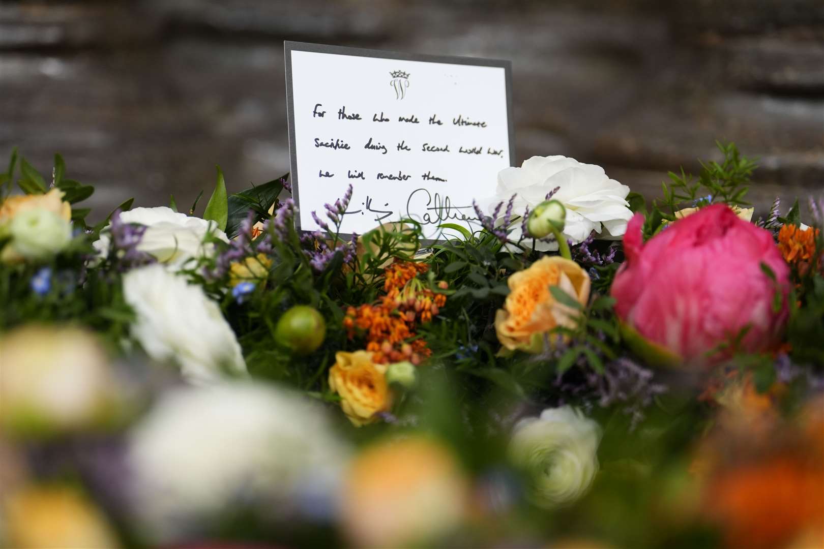 The wreaths, with handwritten notes, have been made up using seasonal flowers that would have been in bloom in May 1945 (Jordan Pettitt/PA)