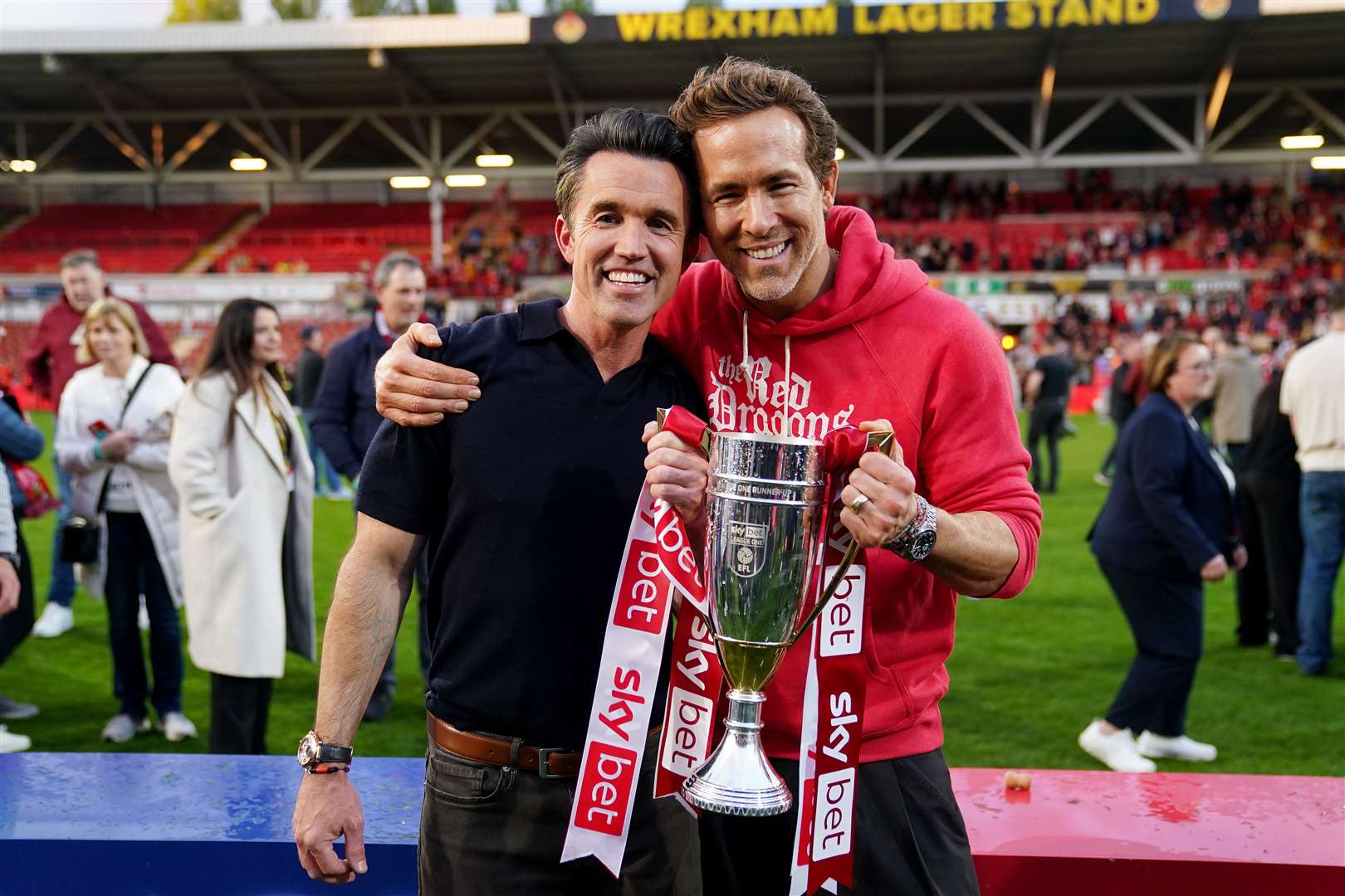 Wrexham co-owners Ryan Reynolds and Rob McElhenney celebrate with the trophy after the Sky Bet League One match on Saturday (Martin Rickett/PA)