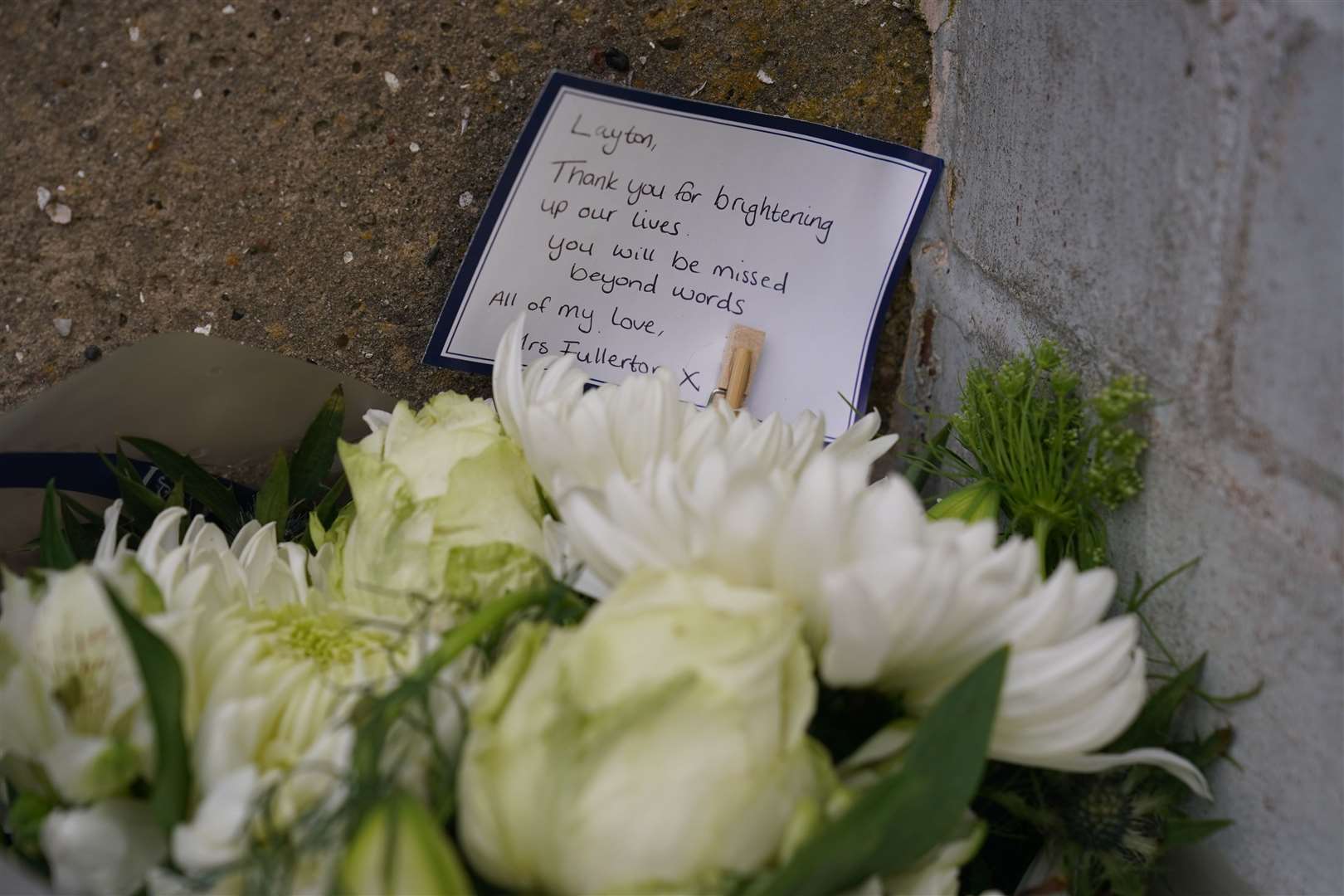Floral tributes left by the gates of Fairfield Industrial Park (Owen Humphreys/PA)