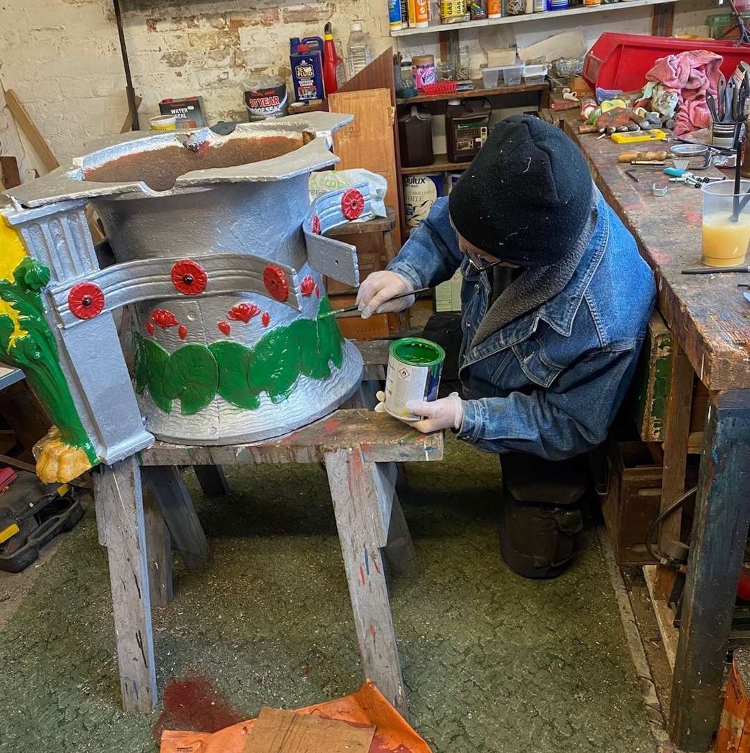 Kelvin Adams at work painting the water lilies that grace the base of the centrepiece