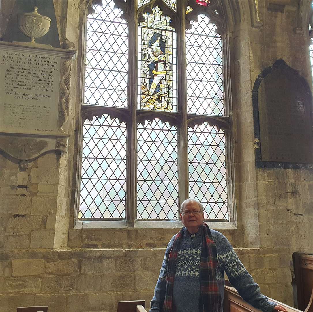 Father Jonathan Sibley against the medieval window in St Mary's Church, Long Sutton.